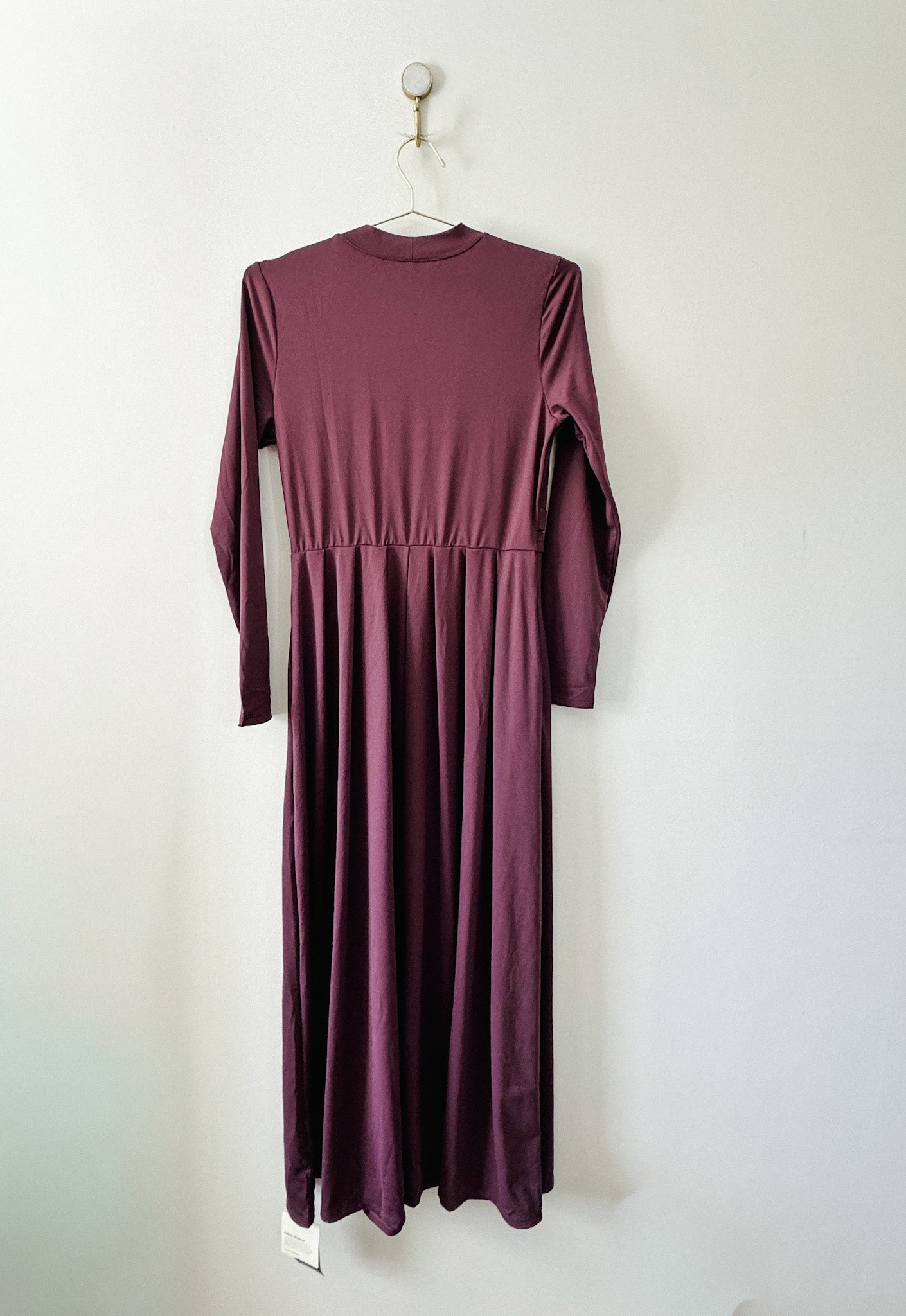 Back of purple Halara maxi dress hanging on a white wall