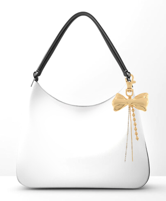 White handbag with a gold bow charm on a white background