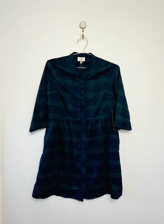 Dark green dress on a hanger against a white background