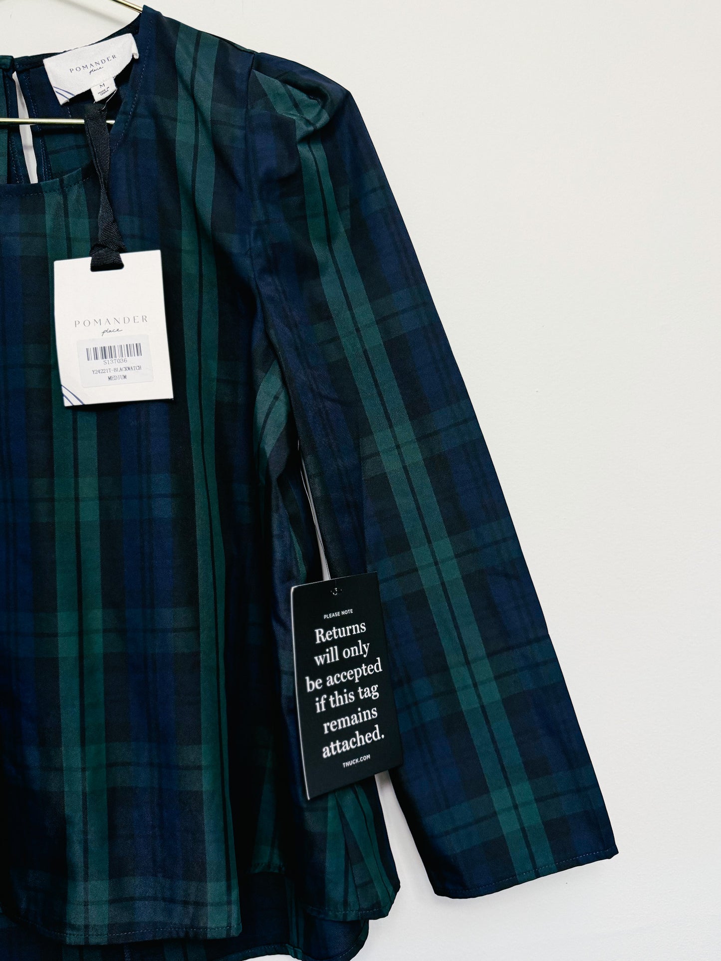 Green plaid shirt with tags on a white background