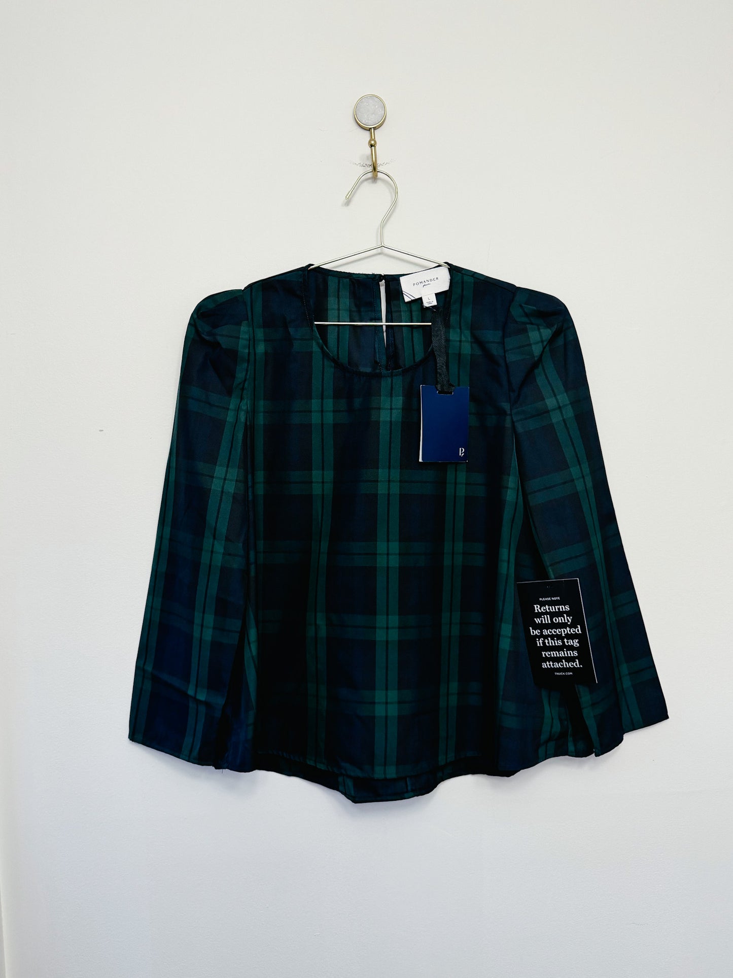 Green plaid shirt on a hanger against a white background