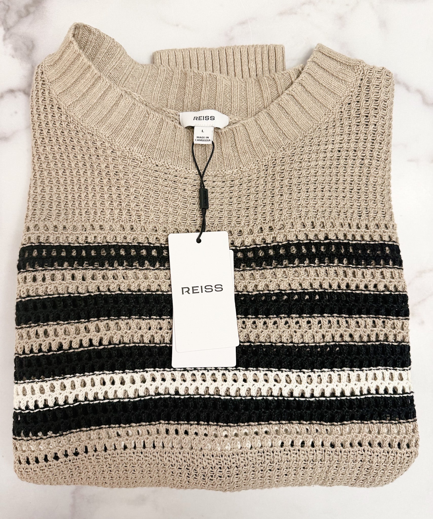 Beige and black striped sweater with a Reiss tag on a light gray background