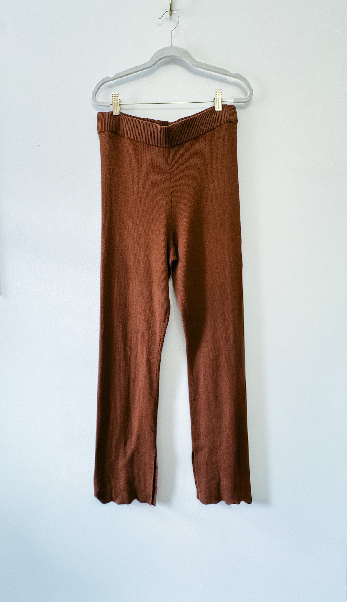 Brown pants hanging on a white background