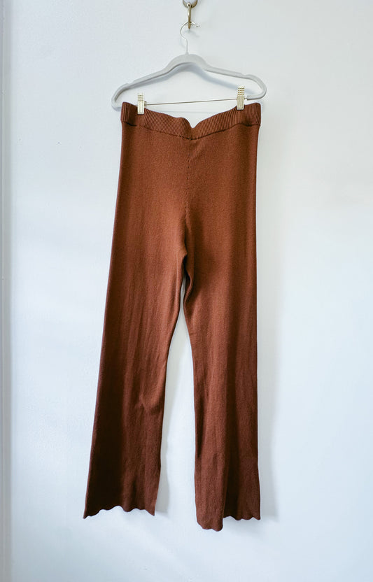 Brown pants on a hanger against a white background