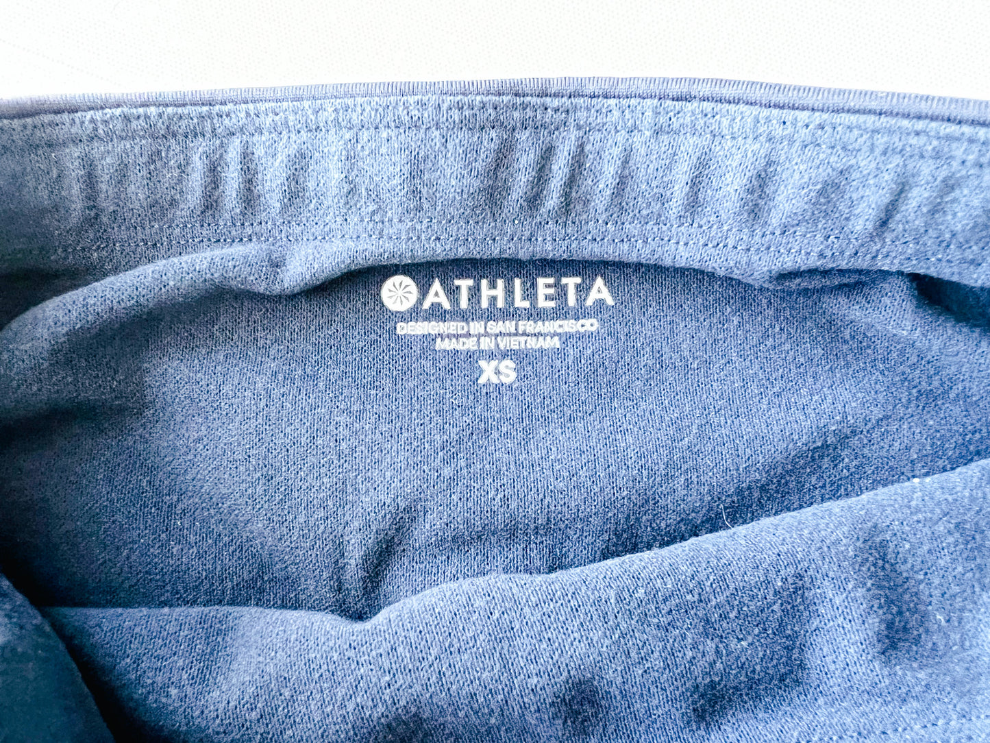 size tag image of athleta fleece lined navy blue winter athletic tights. 